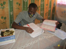 Teacher Byaruhanga Ronald marking home study work (2)