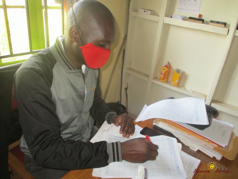 Teacher Irumba Deogratious marking home study work (8).JPG