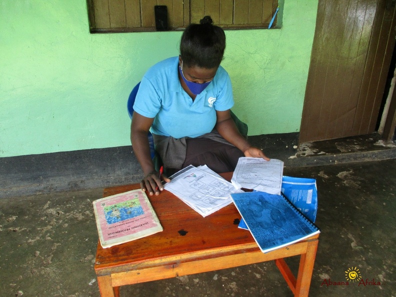 Teacher Tuhaise Goretti marking her pupils home study work (1).JPG